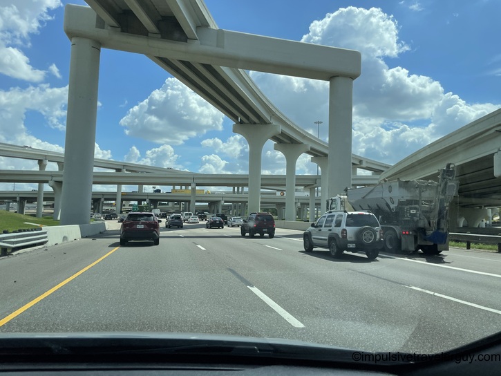 Complex multi-level highway interchange with elevated concrete overpasses and traffic moving underneath