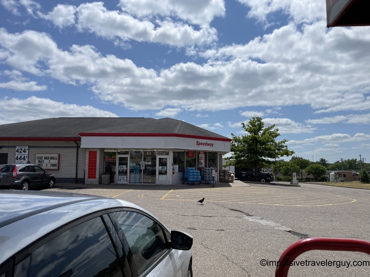 Speedway gas station and convenience store exterior with parking lot in foreground under partly cloudy sky