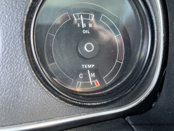 Close-up of the Cougar's combination oil pressure and temperature gauge cluster — oil pressure reading a healthy 45 psi, but the temperature needle sitting right at the edge of the red zone near H.