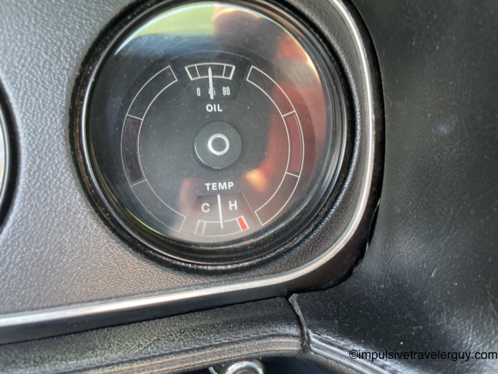 Second shot of the Cougar's oil and temperature gauge with similar readings — oil pressure steady, temperature gauge needle hovering near the hot mark during the summer drive.