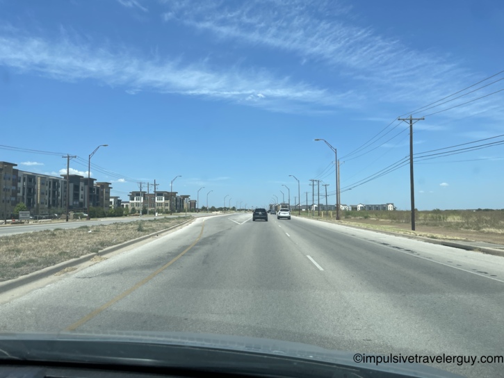 View from a vehicle driving down A.W. Grimes in Round Rock, passing newly constructed apartment complexes.