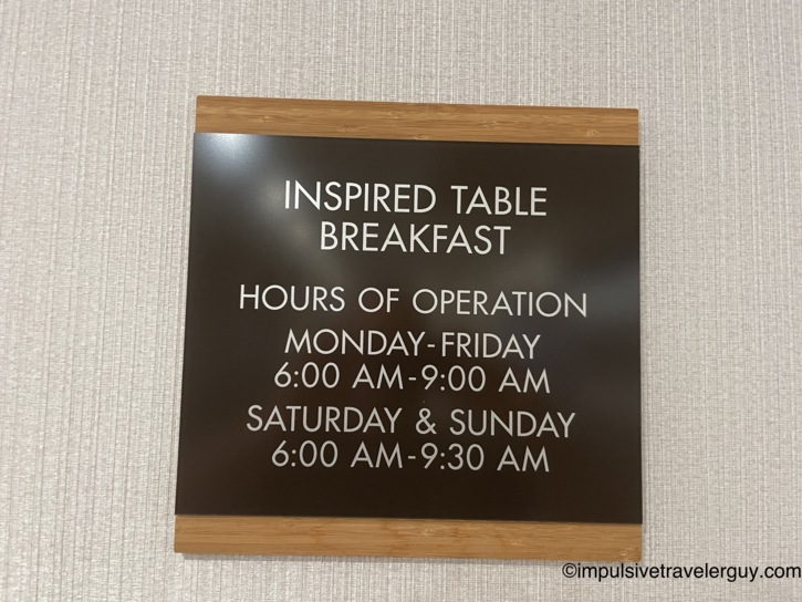 A hotel sign detailing the 'Inspired Table Breakfast' hours of operation.